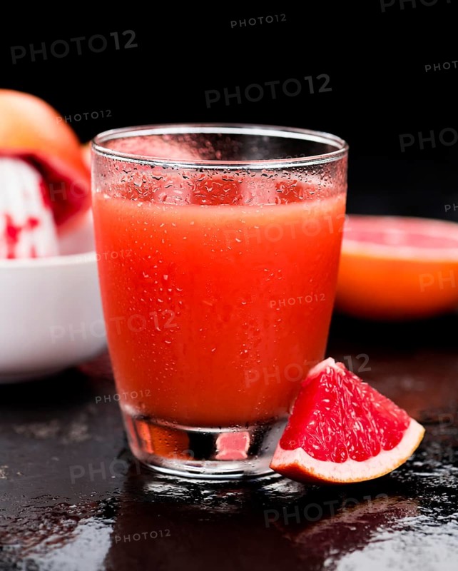 Portion of freshly squeezed Grapefruit Juice on a vintage background (selective focus, close-up shot)
