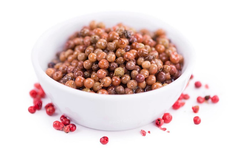 Preserved Pink Peppercorns isolated on white background, selective focus, close-up shot