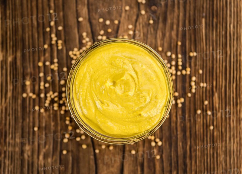 Mustard as high detailed close-up shot on a vintage wooden table (selective focus)