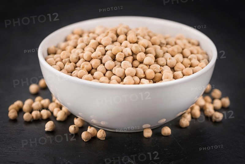 Some dried Chickpeas on a slate slab as detailed close-up shot, selective focus