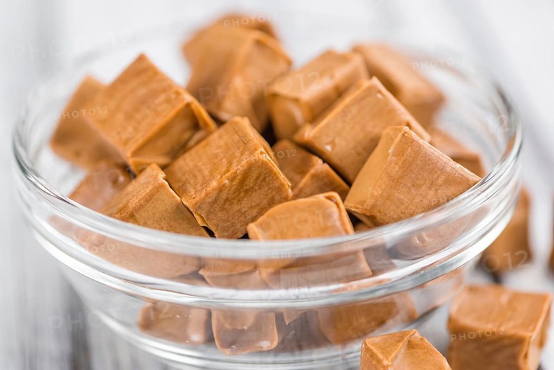 Caramel on a vintage background as detailed close-up shot (selective focus)