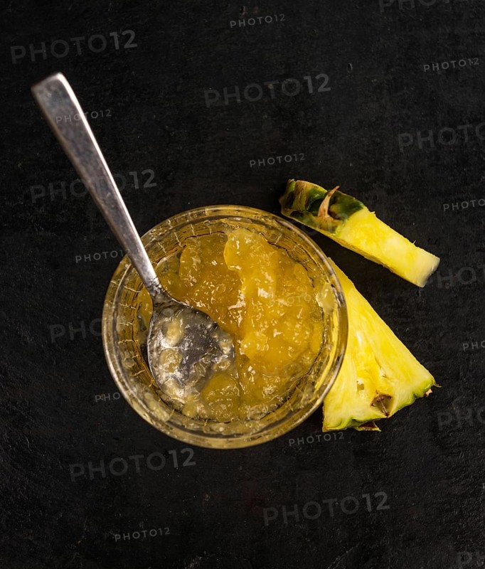 Portion of Pineapple Jam as detailed close up shot on a slate slab, selective focus