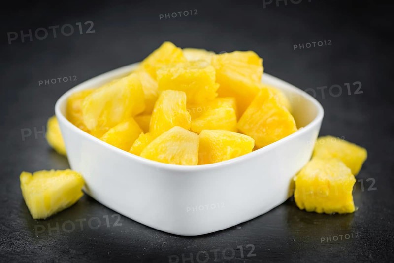 Portion of Sliced Pineapple as detailed close up shot on a slate slab, selective focus
