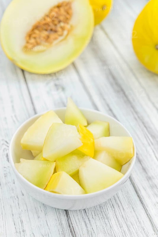 Honeydew Melon on an old wooden table as detailed close-up shot (selective focus)