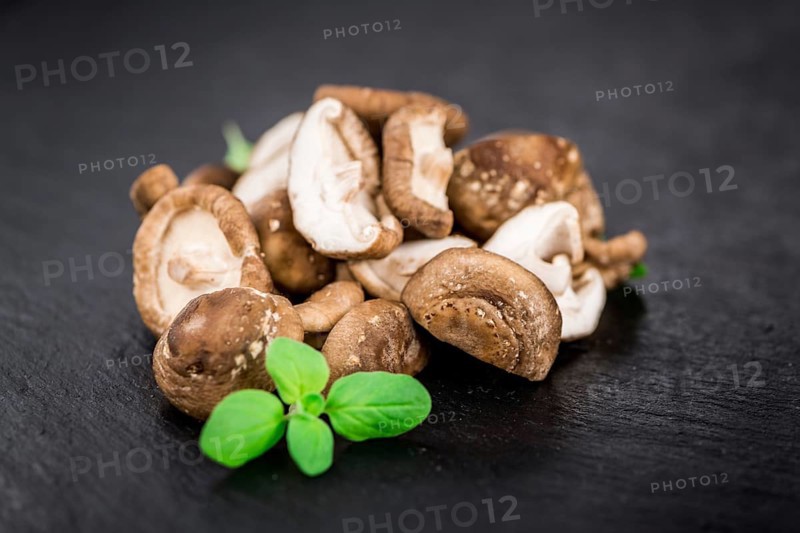 Portion of Shiitake mushrooms as detailed close up shot on a slate slab, selective focus