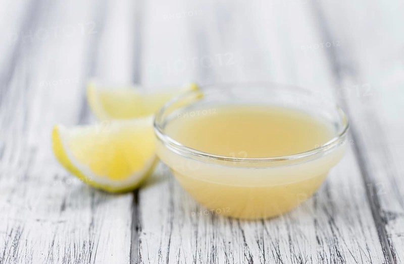 Fresh made Juice (lemon) on an old and rustic wooden table (selective focus, close-up shot)