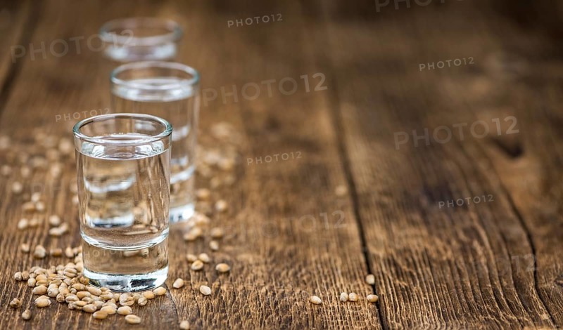 Vintage wooden table with Wheat Liqueur (selective focus, close-up shot)