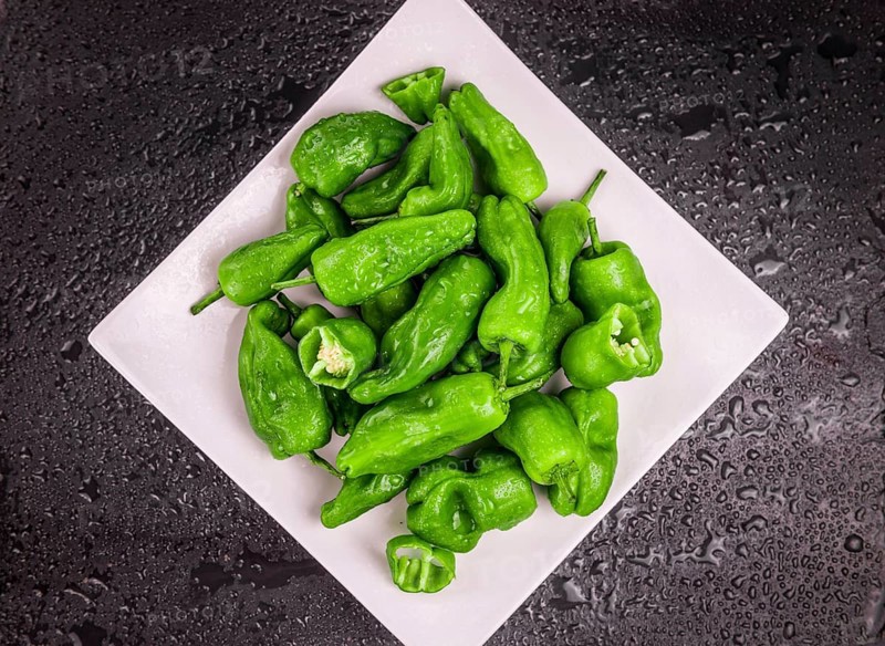 Portion of Raw Pimientos on a rustic slate slab, selective focus, close-up shot
