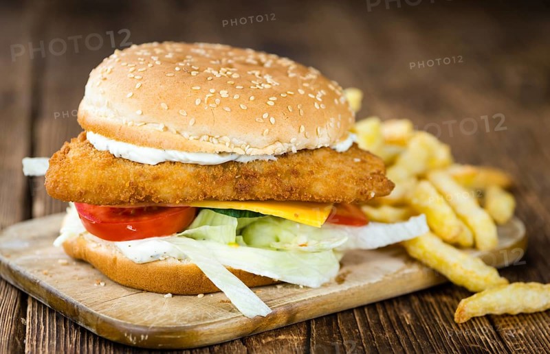 Homemade Fish Burger (close-up shot, selective focus) on a wooden table