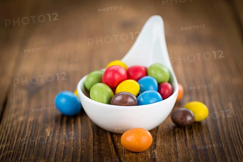 Fresh made Cocolate coated Peanuts on a vintage background (close-up shot)
