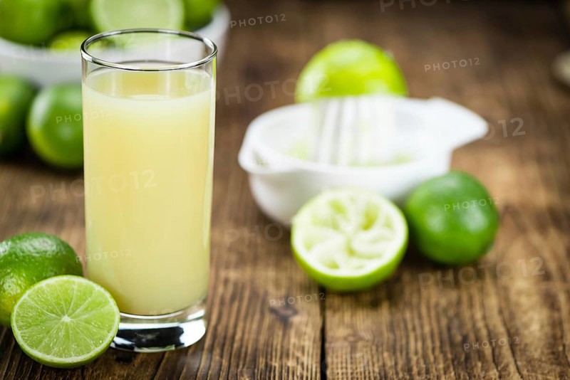 Fresh made Fresh Lime Juice on an old and rustic wooden table (selective focus, close-up shot)