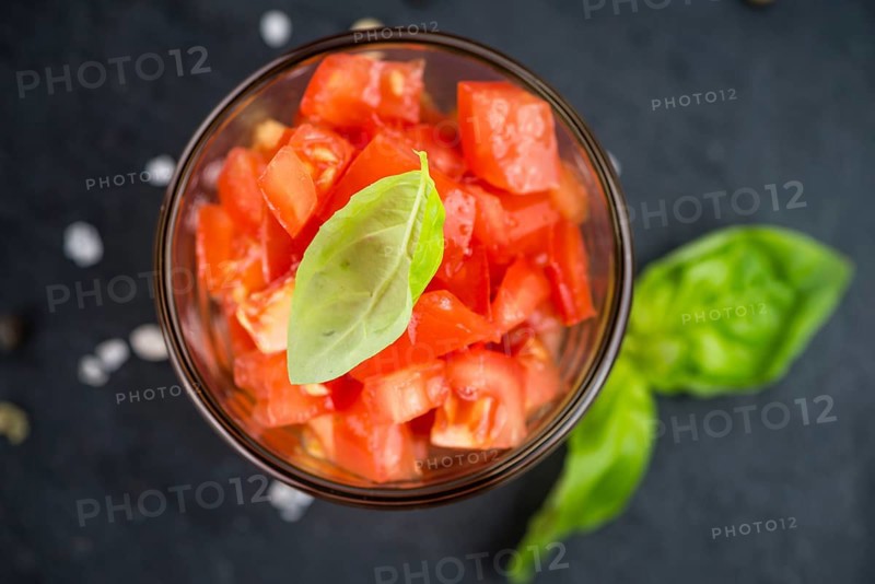 Portion of Cutted Tomatoes as detailed close up shot on a slate slab (selective focus)
