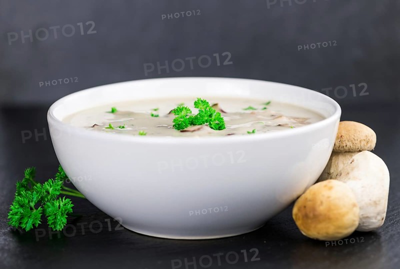 Some Porcini Soup on a slate slab as detailed close-up shot, selective focus