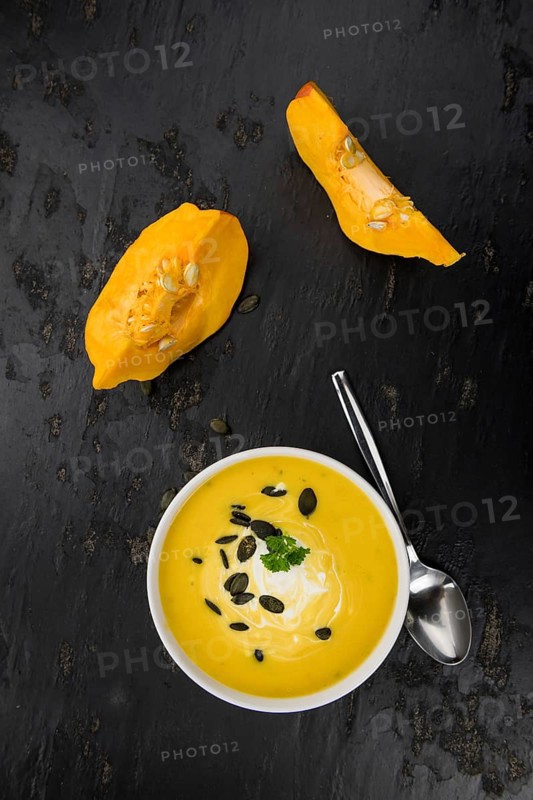 Homemade Pumpkin Soup (selective focus) on rustic background as close-up shot