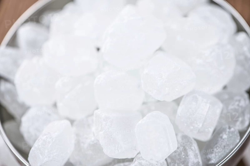 Portion of Rock Sugar (selective focus) on a wooden table