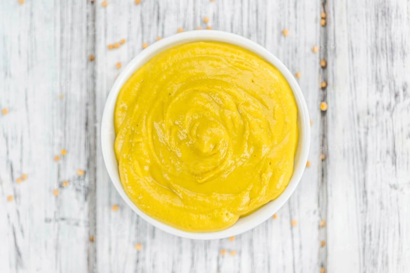 Mustard as high detailed close-up shot on a vintage wooden table (selective focus)
