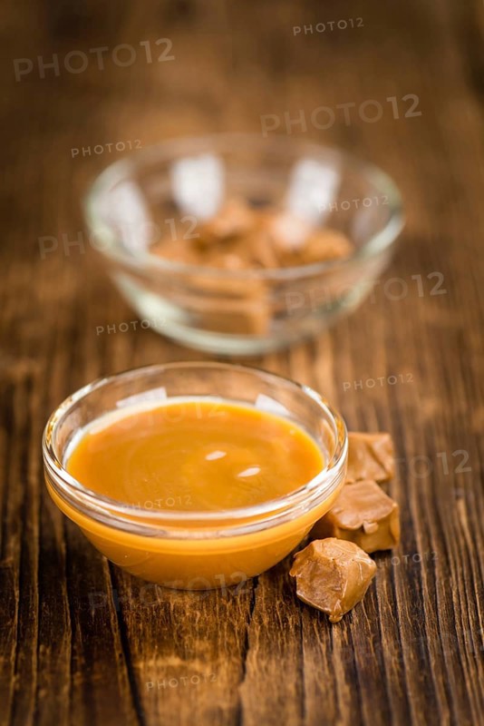 Caramel Sauce on a vintage background as detailed close-up shot (selective focus)