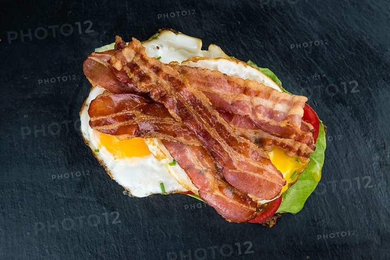 Slate slab with a Bacon and Egg Sandwich (close-up shot)