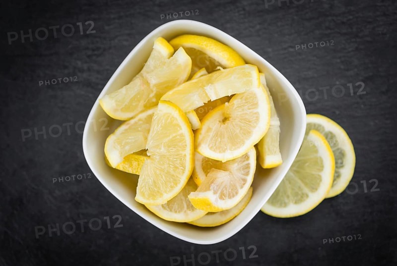 Some fresh Lemon Slices on a vintage slate slab (selective focus, close-up shot)