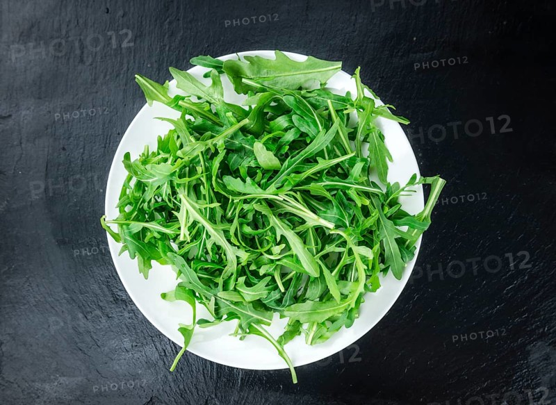 Slate slab with Arugula (detailed close-up shot, selective focus)