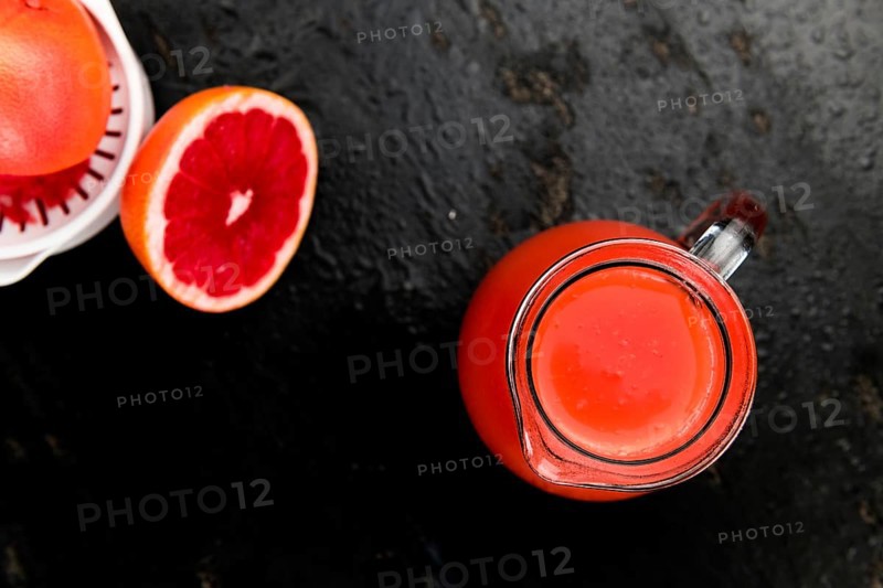 Some freshly squeezed Grapefruit Juice on a vintage background (close-up shot, selective focus)