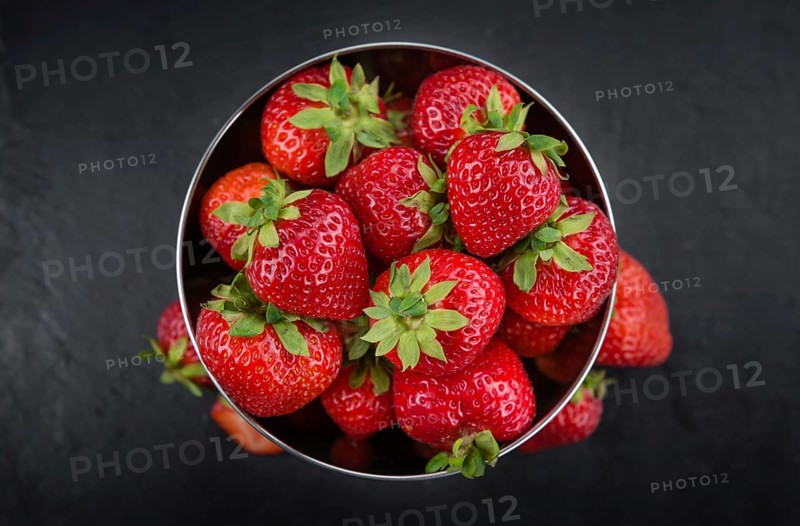 Some Strawberries on a slate slab as detailed close-up shot, selective focus
