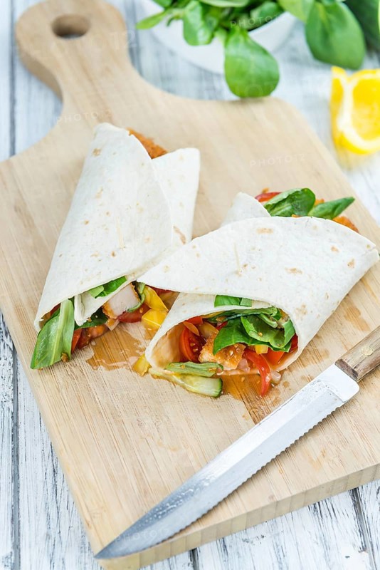 Chicken Wraps on a wooden table as detailed close-up shot (selective focus)