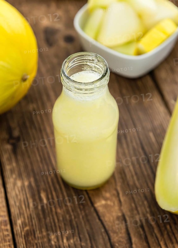 Honeydew Melon smoothie (close-up shot, selective focus) on a wooden table