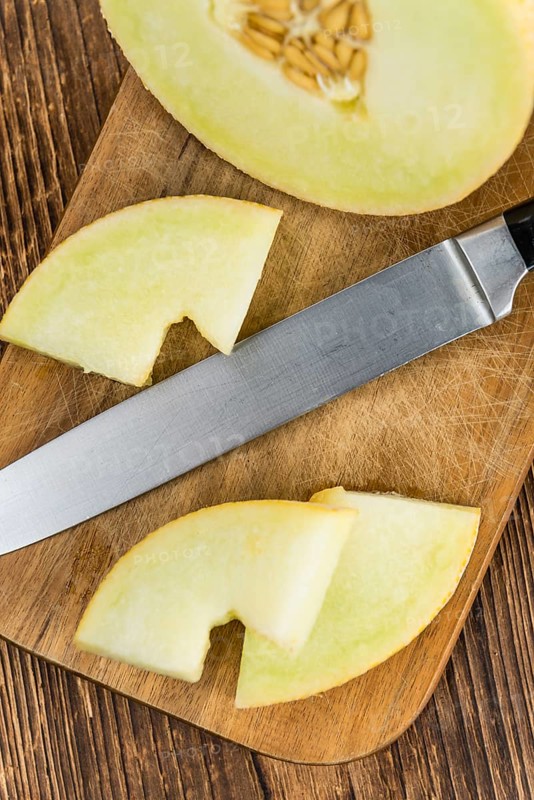 Fresh made Honeydew Melon on a vintage background (close-up shot)