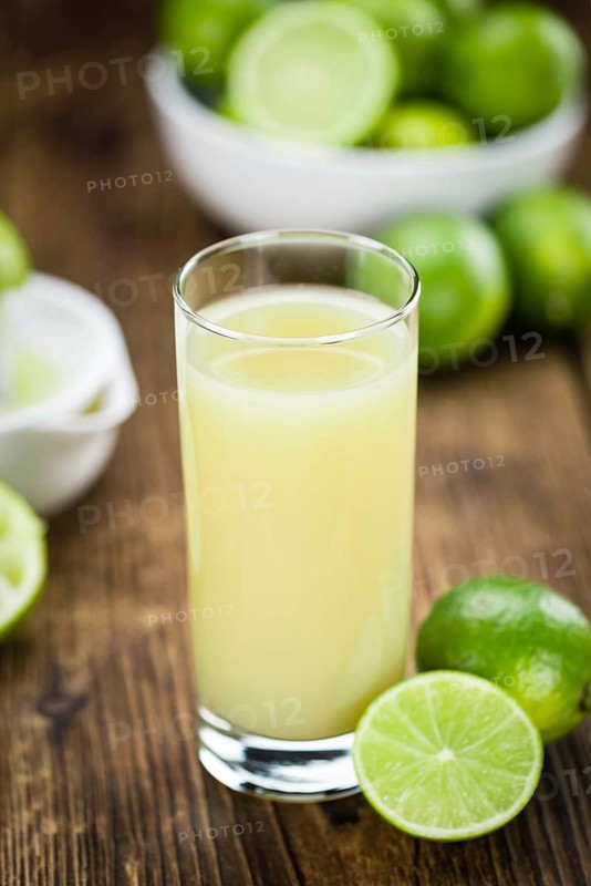 Lime Juice on a vintage background as detailed close-up shot (selective focus)