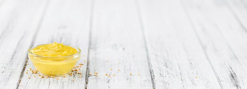 Mustard as high detailed close-up shot on a vintage wooden table (selective focus)