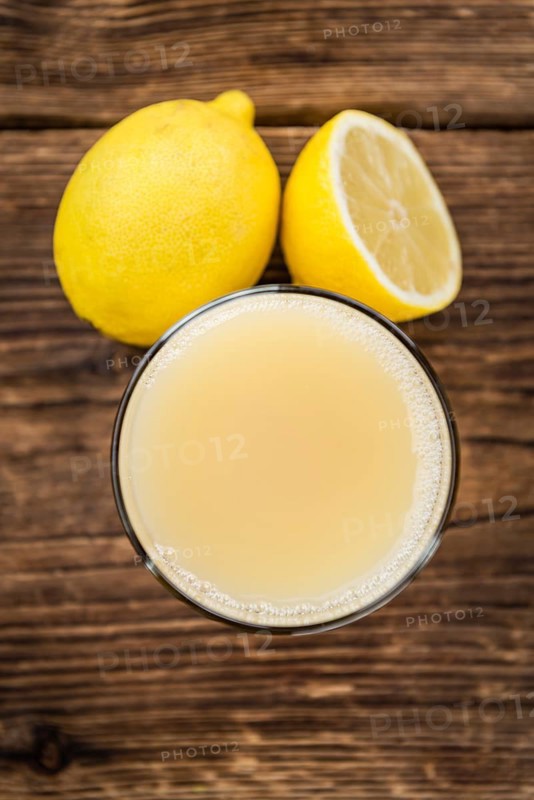 Homemade Lemon Juice on an wooden table (selective focus) as detailed close-up shot