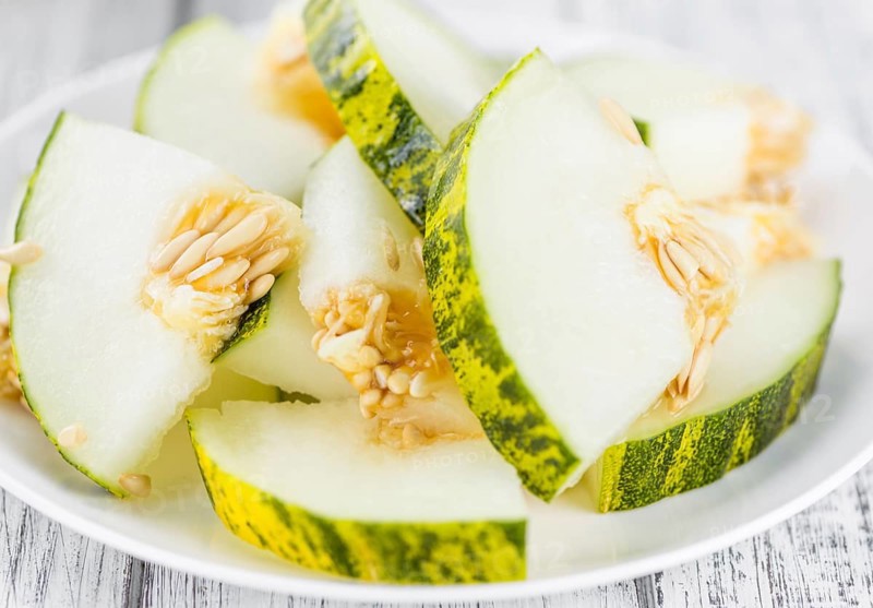 Fresh Futuro Melon as high detailed close-up shot on a vintage wooden table (selective focus)