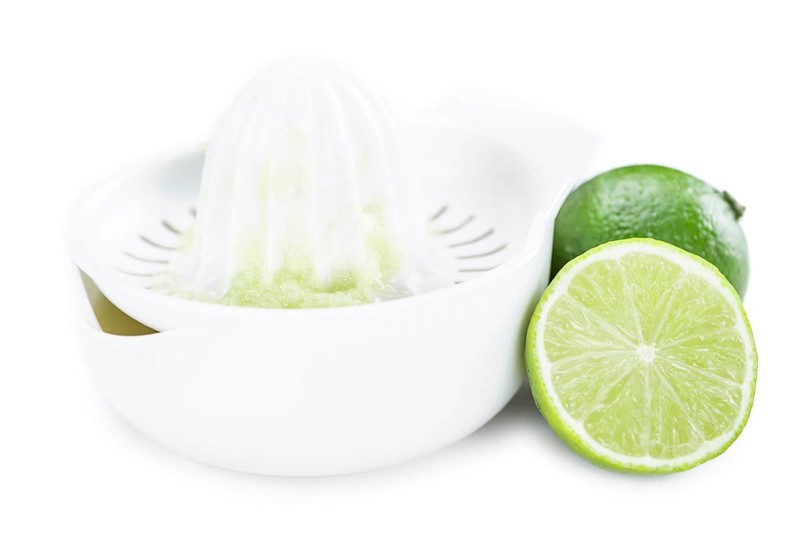 Portion of Lime Juice (as close-up shot) isolated on white background