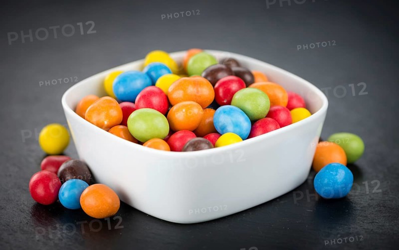Portion of Cocolate coated Peanuts as detailed close up shot on a slate slab (selective focus)