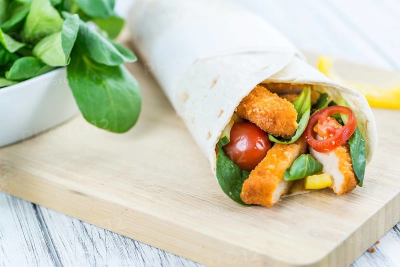 Chicken Wraps on a wooden table as detailed close-up shot (selective focus)