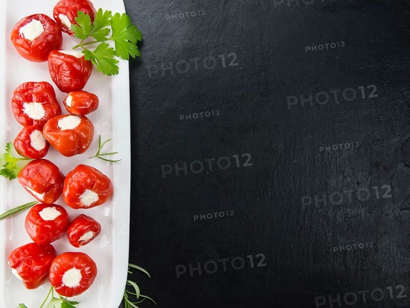 Filled Pimientos on a vintage slate slab (close-up shot, selective focus)