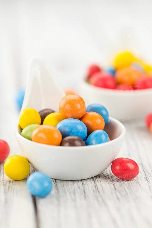 Cocolate coated Peanuts on a vintage background as detailed close-up shot (selective focus)