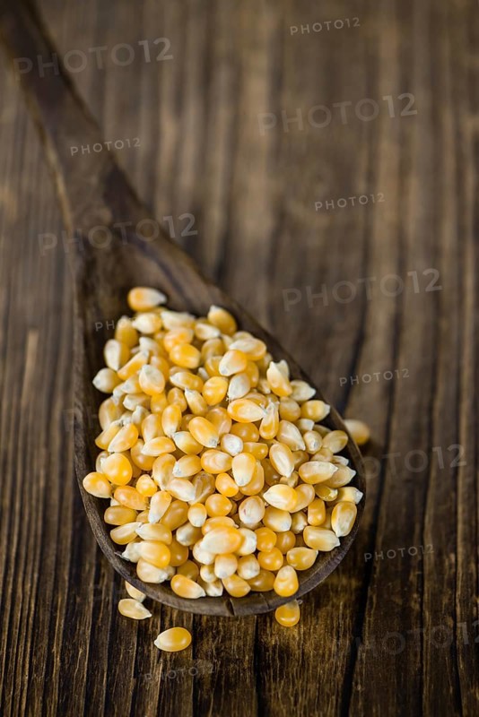 Portion of Corn (detailed close-up shot) on wooden background (selective focus)