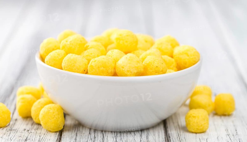 Cheese Balls on rustic wooden background (close-up shot)