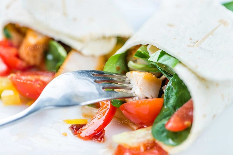 Chicken Wrap (detailed close-up shot, selective focus) on wooden background