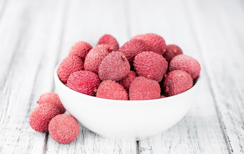 Litchis on rustic wooden background (close-up shot)