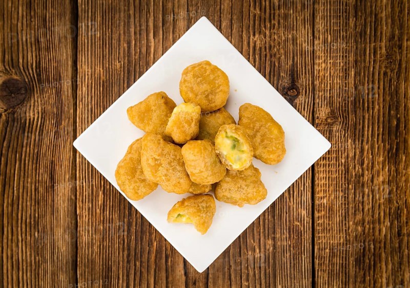 Portion of homemade Chili Cheese Nuggets on wooden background (selective focus, close-up shot)