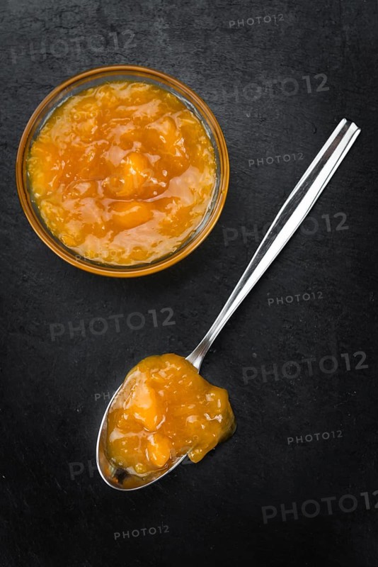 Portion of Apricot Jam on a rustic slate slab (selective focus, close-up shot)