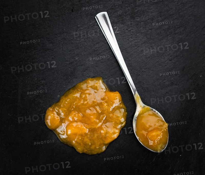 Fresh made Apricot Jam on a vintage background (close-up shot)
