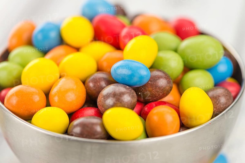 Cocolate coated Peanuts on an old wooden table as detailed close-up shot (selective focus)