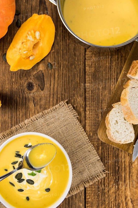 Fresh made Pumpkin Soup (close-up shot) on a vintage background (selective focus)