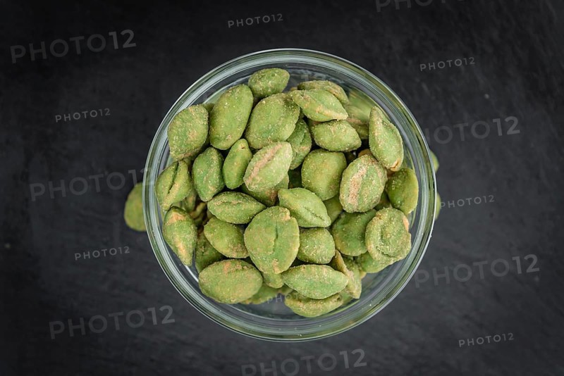 Some fresh Wasabi Peanuts on a vintage slate slab (selective focus, close-up shot)