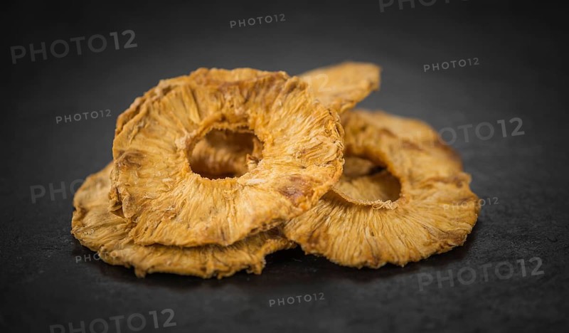 Pineapple rings (dried) on a vintage slate slab as detailed close-up shot, selective focus