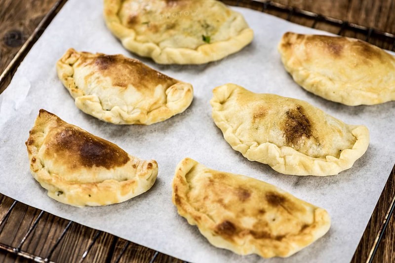 Portion of healthy Empanadas on an old wooden table (selective focus, close-up shot)